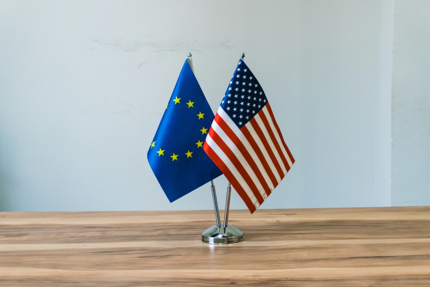 United States and European Union flags on a table, representing international child abduction cases under the Hague Convention