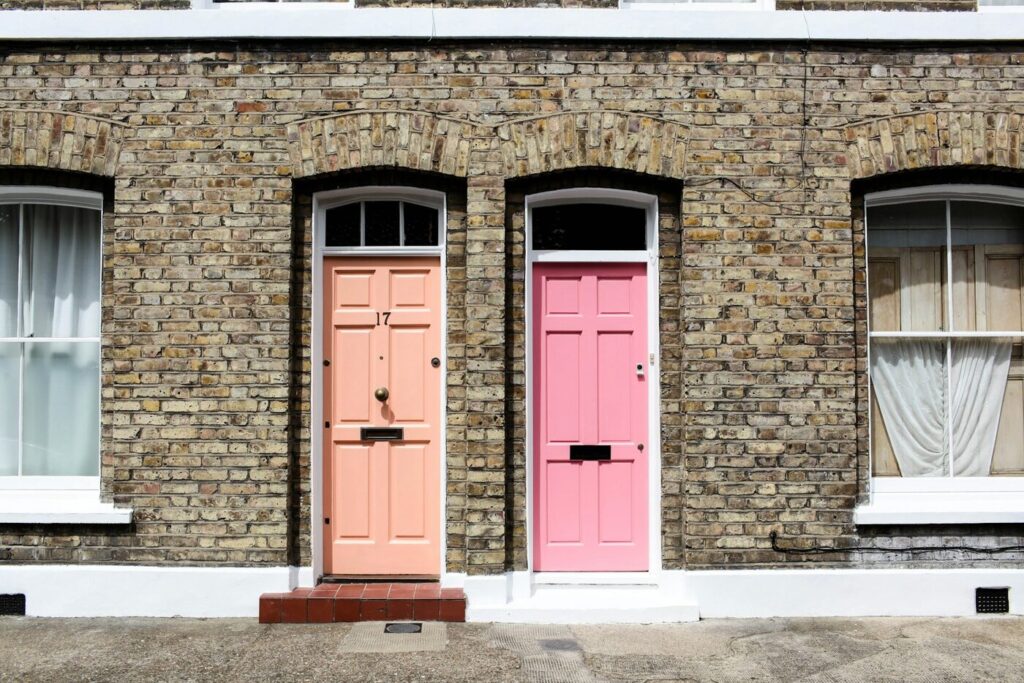 Two front doors side by side on a brick building, a committed intimate relationship when one partner is still married and living in another household