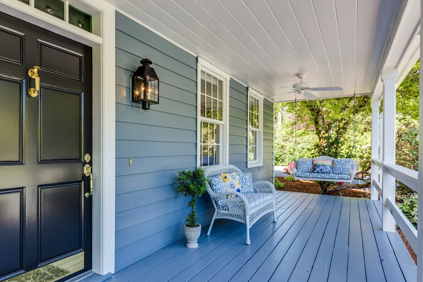 Front porch of a blue house with a bench, the home and property a Washington court divides when a committed intimate relationship ends