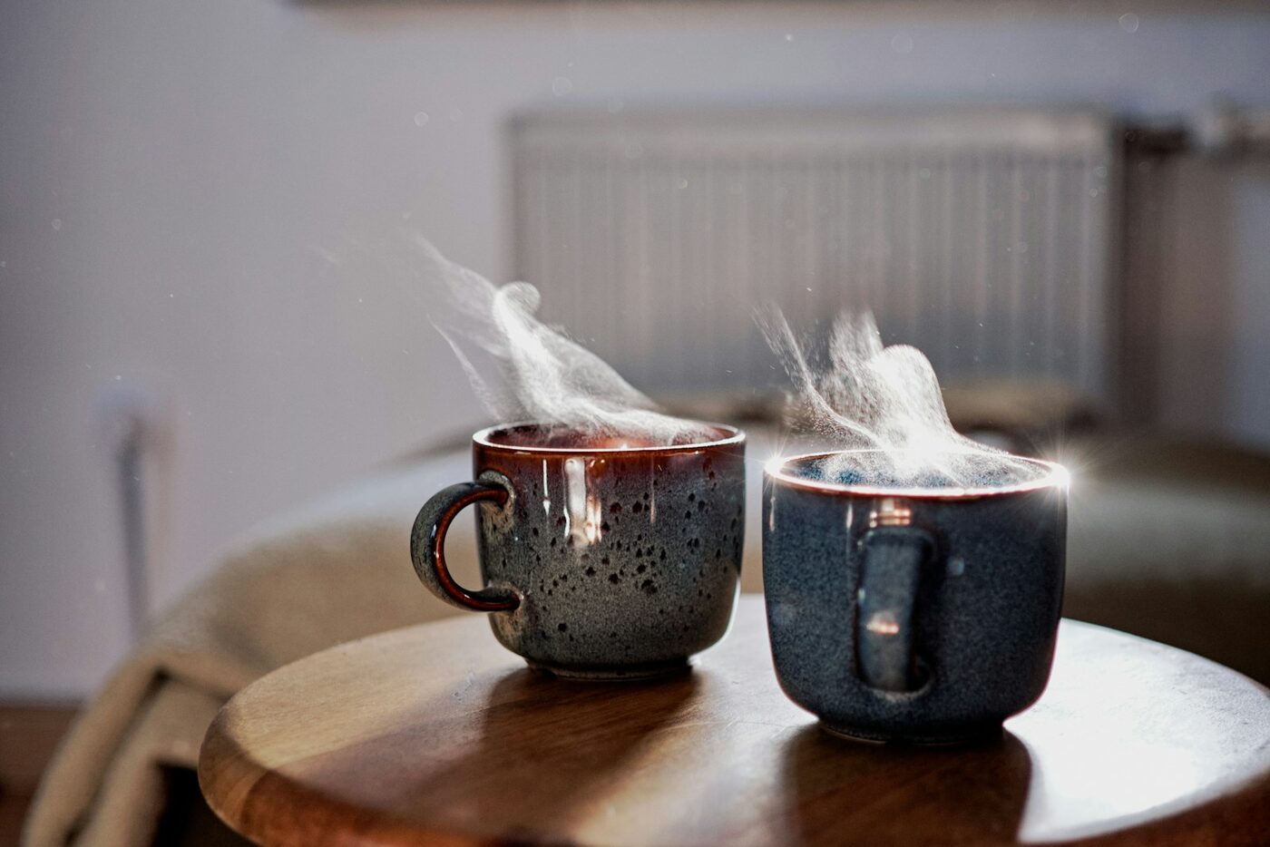 Two steaming coffee mugs on a small wooden table, living together without common law marriage in Washington