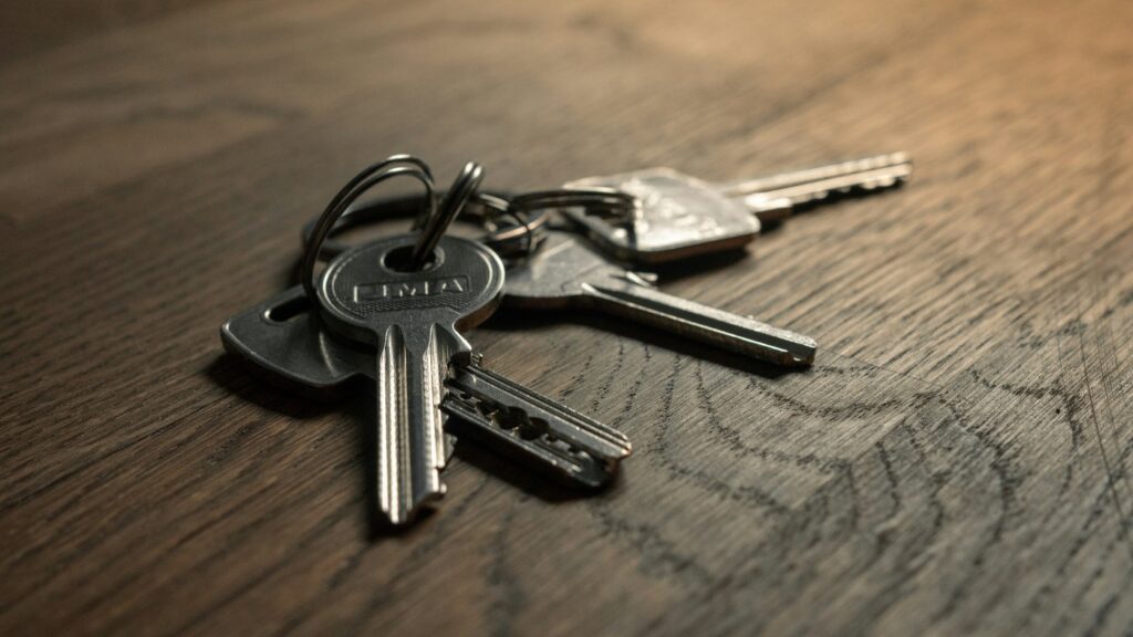 A ring of house keys on a bare wooden table, working out how to pay for a divorce when your spouse controls the money