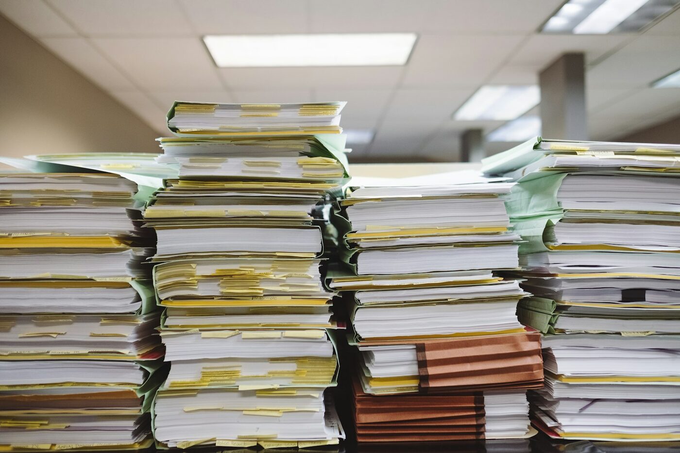 Stacks of paper files and folders on an office shelf, the records used to prove a committed intimate relationship existed in Washington