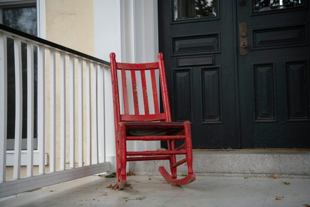 A single empty red rocking chair on a front porch, a surviving partner's property rights when an unmarried partner dies in Washington